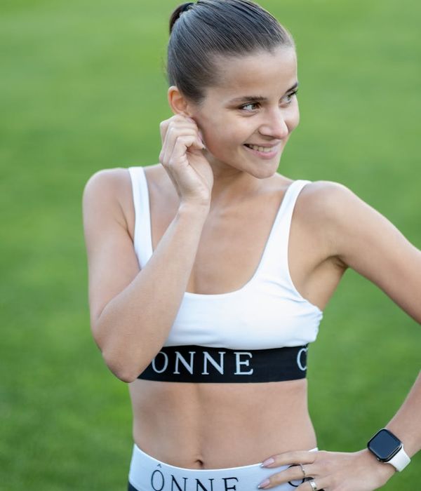 A smiling woman in sportswear looking relaxed and happy after a workout.